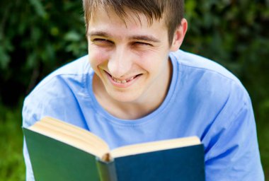 Mutlu genç adam yaz parkında bir kitap okudu.