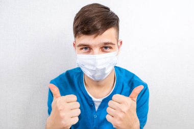 Grip Maskeli Mutlu Genç Adam Odadaki Duvarda Başparmak Hareketi Gösteriyor