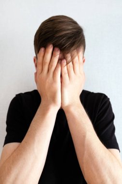 Beyaz Duvar 'ın yanındaki üzgün genç adam. Yakın plan.