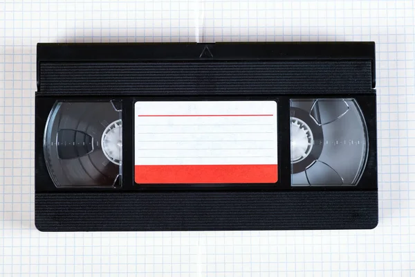 正方形の紙の背景にレトロなビデオテープカセットが閉じ — ストック写真