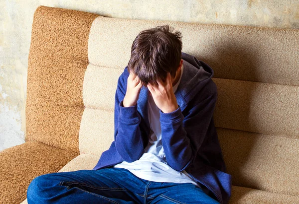 Smutny Młody Człowiek Płacze Kanapie Przy Ścianie Pokoju — Zdjęcie stockowe