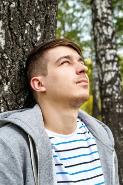 Ormandaki Ağaç Gövdesi 'nin yanındaki genç adam.