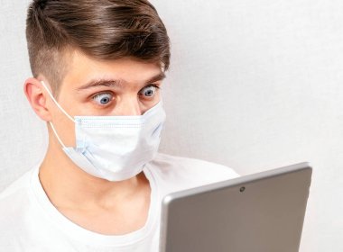 Grip Maskeli Genç Adam 'ı duvarın orada bir tabletle şok etti.