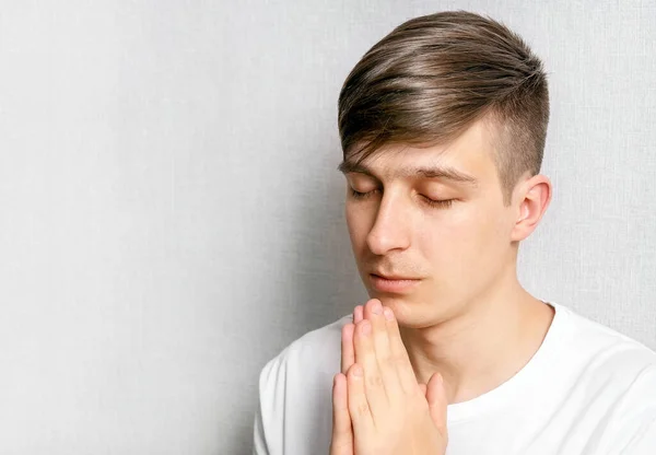 Молодой Человек Молится Белой Стены Крупным Планом — стоковое фото