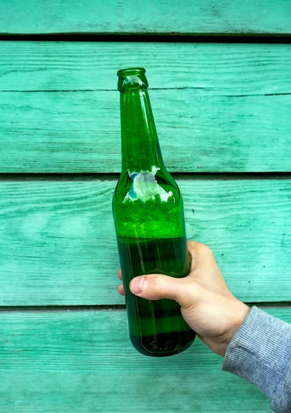 Persona Sostiene Una Botella Cerveza Primer Plano Pared Madera —  Fotos de Stock