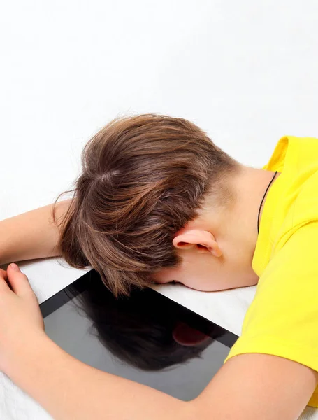 疲れている子供はベッドの上のタブレットコンピュータで寝る — ストック写真