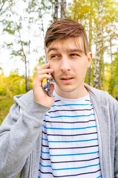 Jonge Man Met Een Mobiele Telefoon Het Herfstbos — Stockfoto