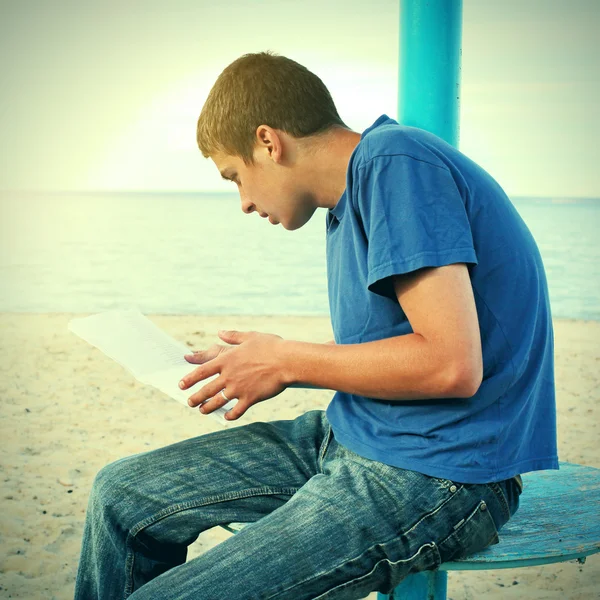 Adolescente lendo na praia — Fotografia de Stock
