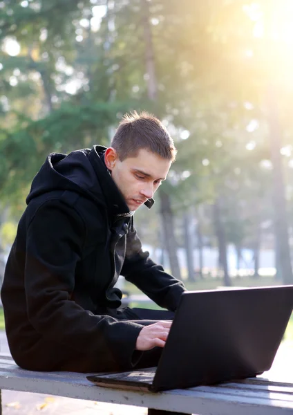 Młody człowiek z zewnątrz laptopa — Zdjęcie stockowe