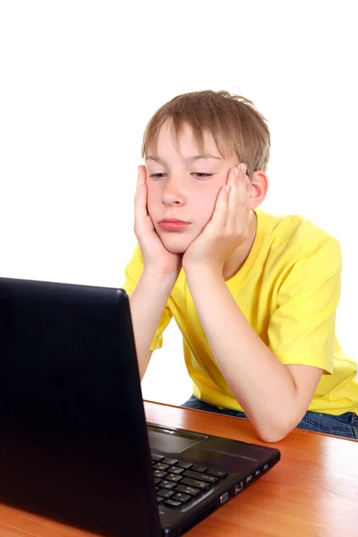 Niño aburrido con ordenador portátil —  Fotos de Stock