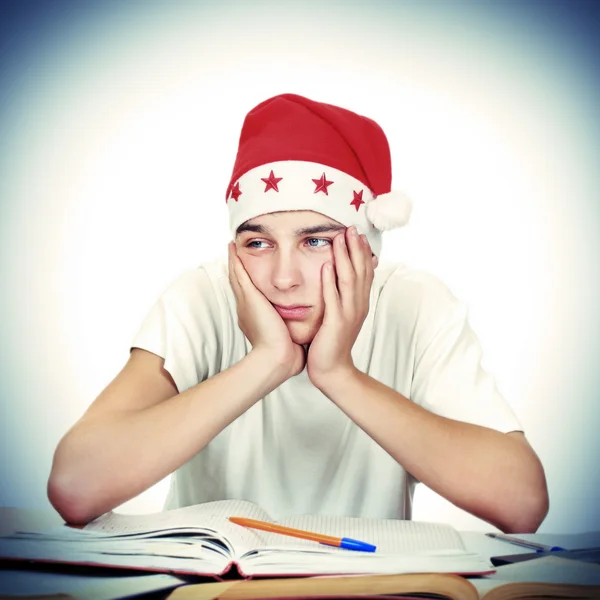 Gelangweilte Studentin mit Weihnachtsmütze — Stockfoto