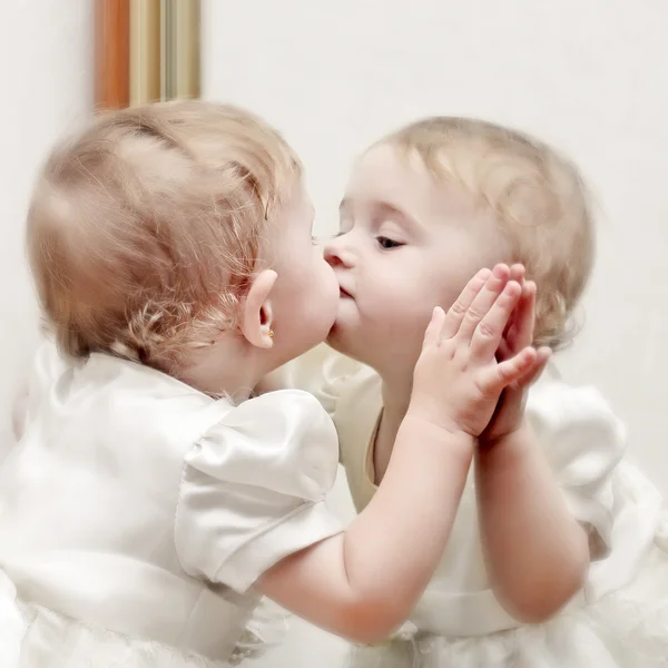 Bambino baciare uno specchio Foto Stock