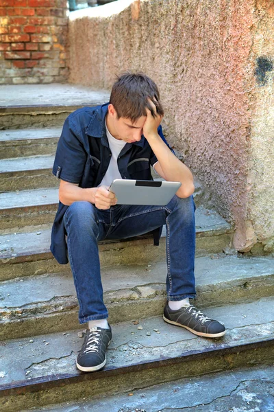 Adolescente triste com computador tablet — Fotografia de Stock