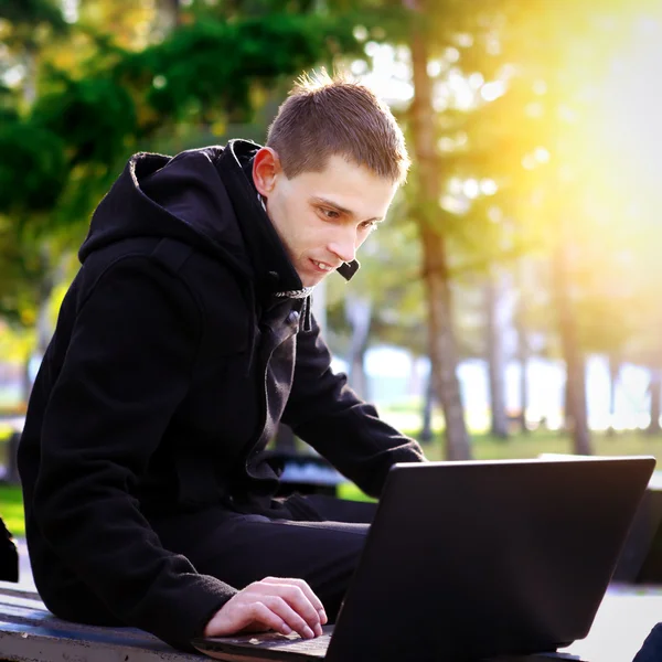 Człowiek z laptopem w parku — Zdjęcie stockowe