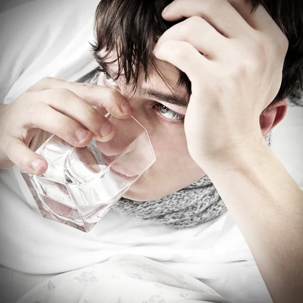 Adolescente con gripe bebe agua — Foto de Stock