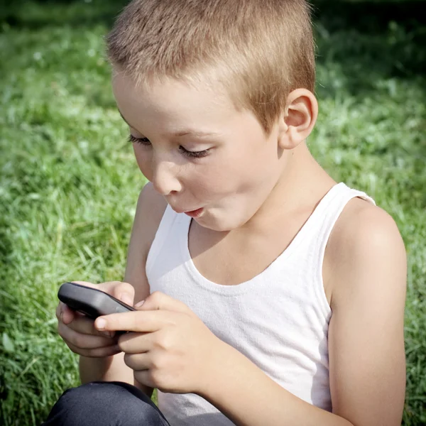 Kid met cellphone buiten — Stockfoto