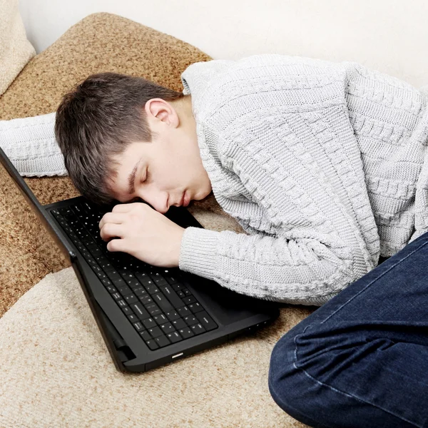 Молодой человек спит на ноутбуке — стоковое фото