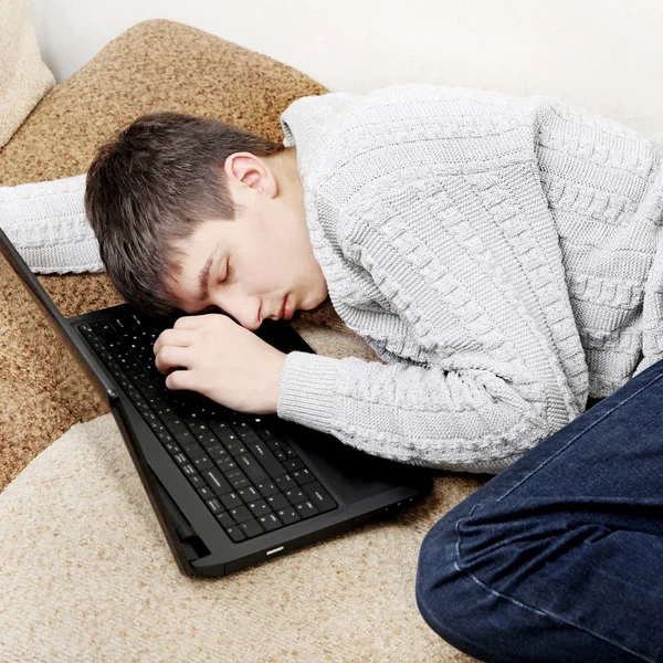 Junger Mann schläft auf Laptop — Stockfoto