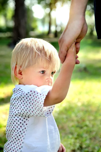 Enfant malheureux tenir la main du parent — Photo