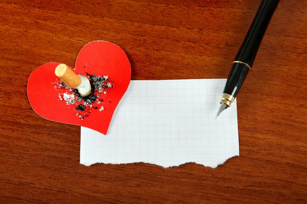 Sigaretta con la forma del cuore e la carta — Foto Stock