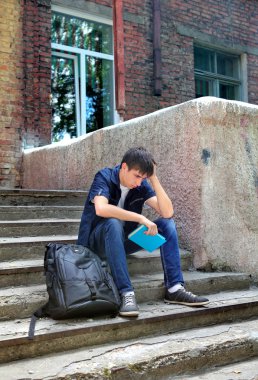 Açık kitap ile üzgün öğrenci