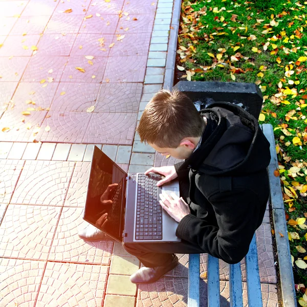 Парень с ноутбуком на улице — стоковое фото
