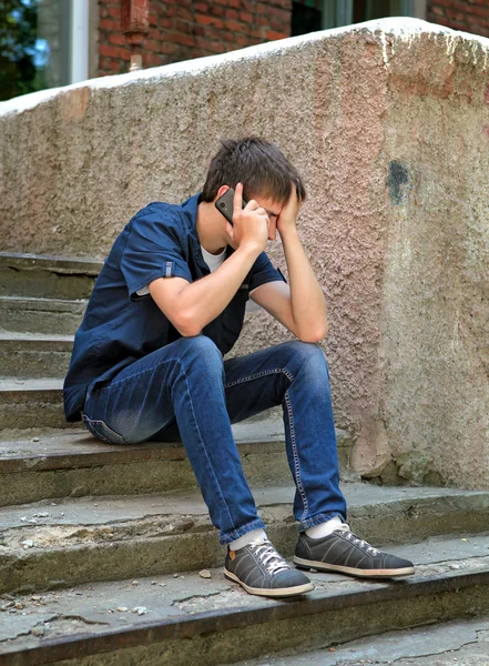 Triste jeune homme avec téléphone portable — Photo