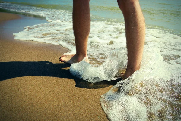 Piernas en la orilla del mar — Foto de Stock