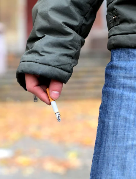 El hombre sostiene un cigarrillo — Foto de Stock