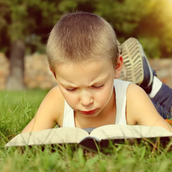 Niño con el libro al aire libre — Foto de Stock