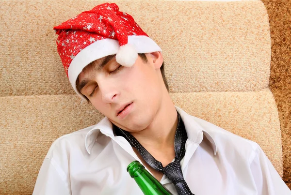 Молодой человек спит в Санта-Клаусе — стоковое фото