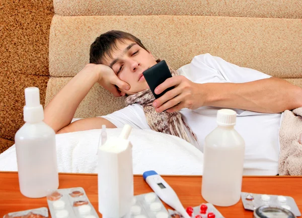 Jovem doente com o telefone — Fotografia de Stock