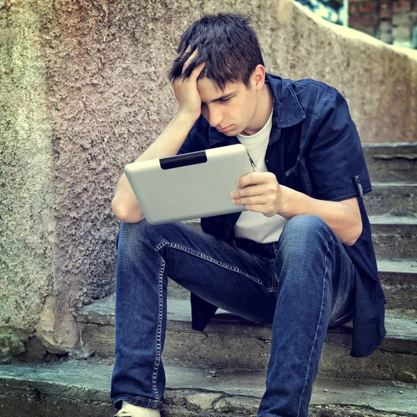 Trauriger junger Mann mit Tablet — Stockfoto