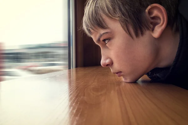 Triste adolescente olhar para a janela — Fotografia de Stock
