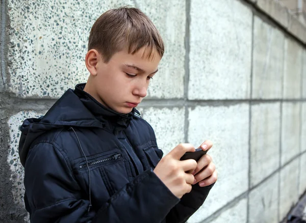 Nastolatek z telefonem komórkowym — Zdjęcie stockowe