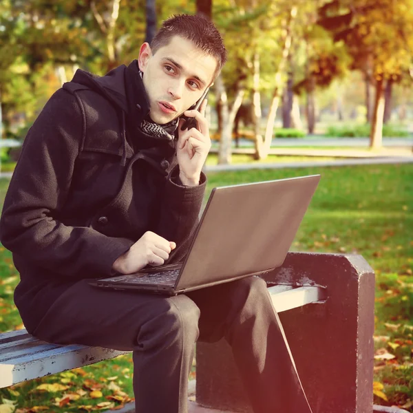 Человек с ноутбуком на улице — стоковое фото