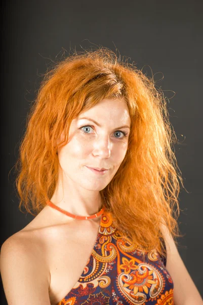 Çiçek elbise kırmızı kıvırcık saçlı genç kadın — Stok fotoğraf