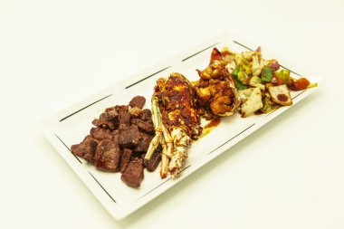 Sörf ve çim, kızarmış Istakoz ve sulu hissesi kızarmış sebze üzerinden bir garnitür ile.