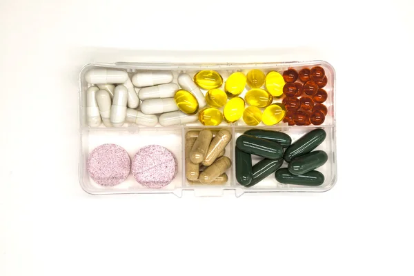 Diverse pillole, farmaci, le pillole nella scatola per farmaci primo piano su sfondo bianco . — Foto Stock