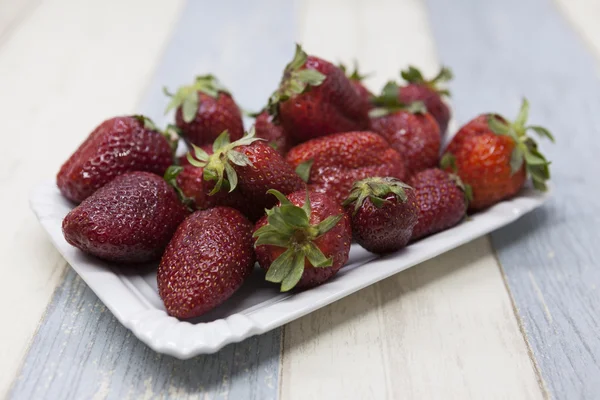 Fresh strawberry on a plate on a blue gray background — Stock Photo, Image