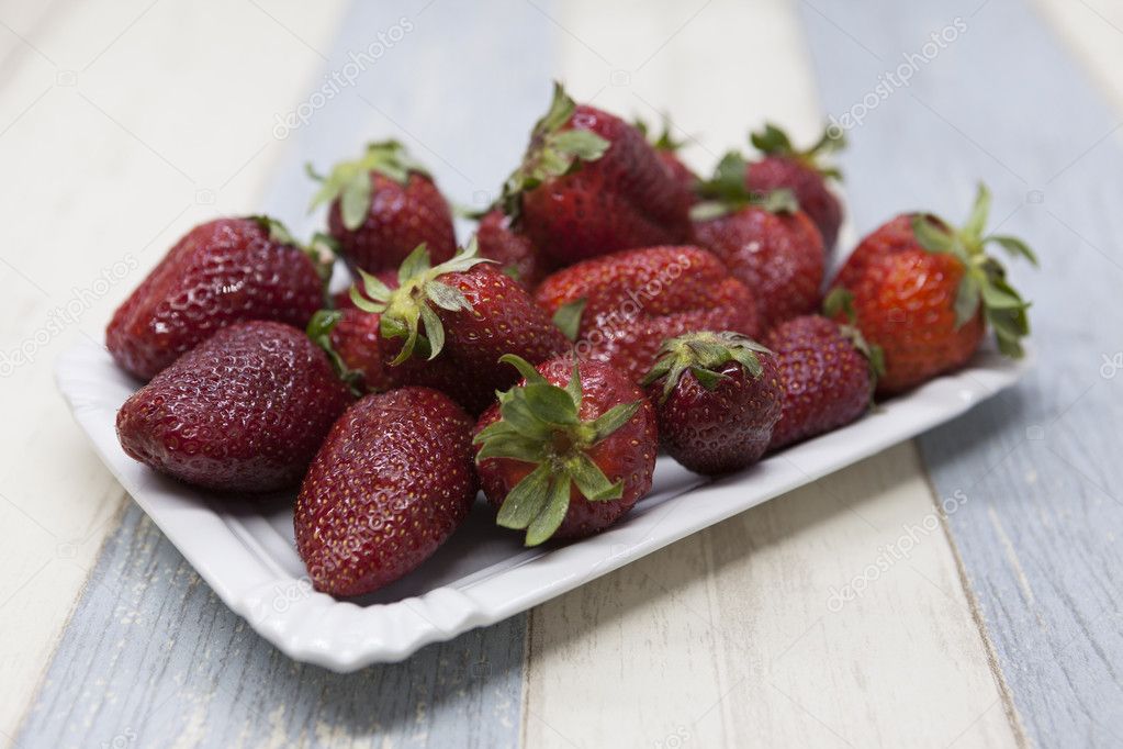 Fresh strawberry on a plate on a blue gray background