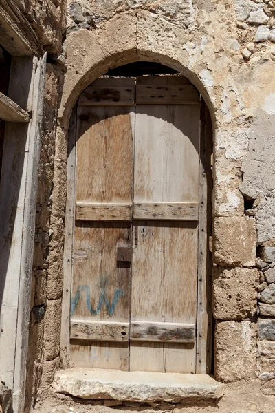 Puerta vieja en las paredes de piedra de las casas del pueblo. Excelente fondo . — Foto de Stock