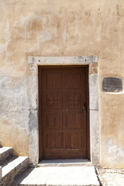 Old door in the stone walls of the village houses. Excellent background. — Stock Photo, Image
