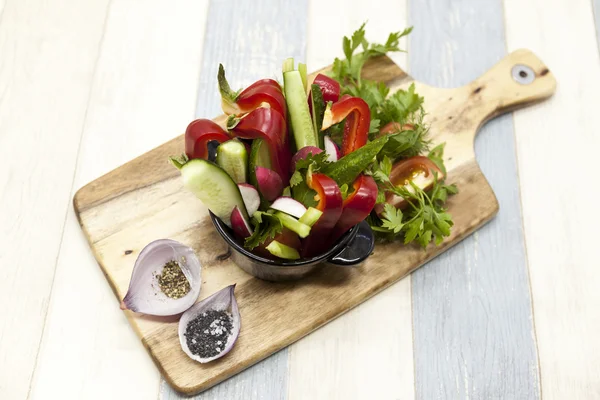 Φρέσκα λαχανικά σε ξύλινη πινακίδα. Κόκκινη πιπεριά, ντομάτα, αγγούρι, ραπανάκι, μαϊντανό, άνηθο υγιεινή διατροφή. — Φωτογραφία Αρχείου