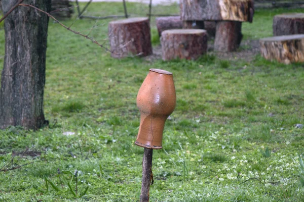 Pote de leite pendura em uma cerca velha de uma jarda de aldeia — Fotografia de Stock