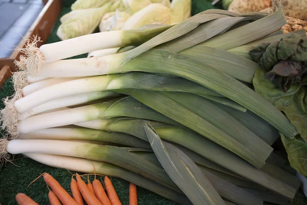 Zanahorias limpias frescas con follaje y cebolla en el mercado — Foto de Stock