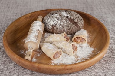 Fresh homemade bread made with  a rolling pin and pastry rolls with jam.