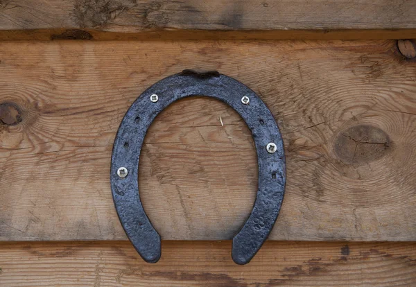 Old horseshoe hanging on the wooden wall. — Stock Photo, Image