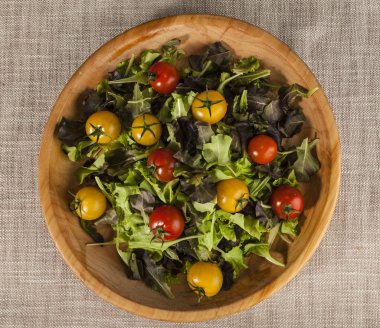 Taze domates marul ve kırmızı ve sarı bir ahşap tepsi