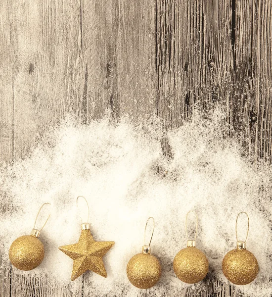 Glittering gold Christmas balls, snowballs, winter snow and star on wooden background — Stock Fotó